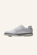 Junge Golfspieler trägt weiße Footjoy Golfschuhe mit schwarzem Logo und Schnürung, auf grünem Golfplatz.