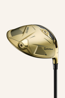 Golfdriver TaylorMade Qi 35 Designer Series Gold, luxuriöses Design, mit Schlägerkopf und Griff, auf einem Golfplatz liegend