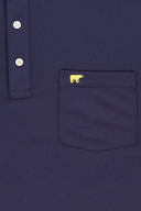 Dunkelblaues Heritage Polo Poloshirt von Jack Nicklaus, lässiges T-Shirt mit Kragen und Logo-Details, auf weißem Hintergrund.