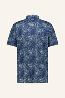Tropical Print Polo von Jack Nicklaus, kurzärmeliges T-Shirt mit buntem tropischem Blumenmuster auf weißem Hintergrund.