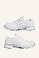 Adidas Tour360 (2024) Golfschuhe in Weiß mit schwarzer Sohle und Schnürung, seitliche Logo-Details, auf grünem Golfplatz