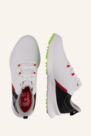 Fußjoy Fuel Junior Golfschuhe in schwarzer Farbe mit Schnürung und rutschfester Sohle, für jungen Golfspieler, auf grünem Rasen.