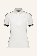 Demi Polo von J. Lindeberg, helles Poloshirt aus Baumwolle mit Knopfleiste und Kragen, auf weißem Hintergrund.