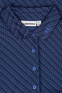 J. Lindeberg Caitlyn Poloshirt in Hellblau, aus Baumwolle, mit Kragen und kurzen Ärmeln, auf weißem Hintergrund.