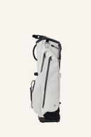 Vessel VLS Lux 4-Way Standbag auf einem grünen Golfplatz, mit mehreren Fächern und Tragegriffen für Golfutensilien.