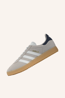 Adidas Gazelle Golfschuhe in Weiß mit schwarzem Logo, seitlicher Schnürverschluss und rutschfester Sohle.
