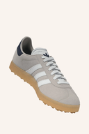 Adidas Gazelle Golfschuhe aus Leder mit Schnürung, weiße und grüne Details, auf transparentem Hintergrund.
