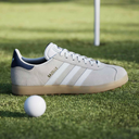 Adidas Gazelle Golfschuhe, schwarze Golfschuhe mit weißem Logo, seitliche Ansicht, sportliches Design für den Golfplatz