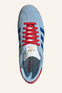 Adidas Gazelle Golfschuhe aus Leder mit grünen und weißen Details auf glattem Golfplatzboden