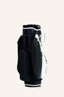 Schwarzfarbenes JuCad First Class Cartbag für Golf, mit mehreren Fächern und Tragegriff, auf einer Golfliege liegend.