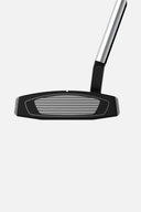 TaylorMade Spider GT Black Putter auf einem Golfplatz, Nahaufnahme des schwarzen Putters mit TaylorMade-Logo.