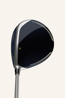 TaylorMade Kalea Gold Driver auf dem Golfplatz, zeigt den Schlägerkopf und Griff in natürlicher Haltung.
