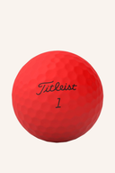 Rote Titleist TruFeel Golfbälle auf weißem Hintergrund, detailreiche Nahaufnahme der Bälle.