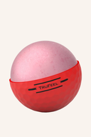 Rote Titleist TruFeel Golfbälle liegen auf einem grünen Golfplatz, bereit für das Spiel.