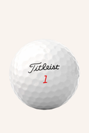 Weiße Titleist TruFeel Golfbälle liegen auf grünem Rasen, bereit für das Golfspiel.