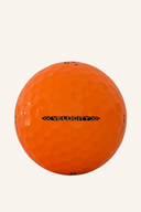 Titleist Velocity Aim 2026 Golfbälle, normale Bälle mit schwarzem und gelbem Design, auf grünem Golfplatz gelegen