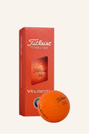 Titleist Velocity Aim 2026 Golfbälle, normale Bälle mit aerodynamischem Design, auf einem Golfplatz liegend.